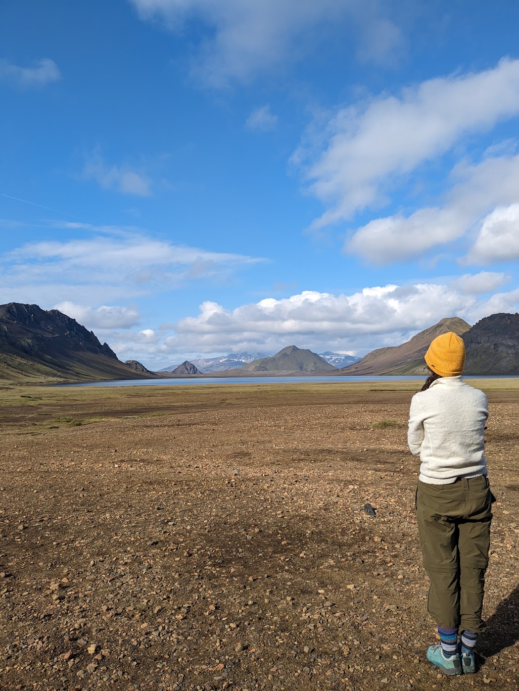Maartje standing at the Álftavötn campground staring over at the lake